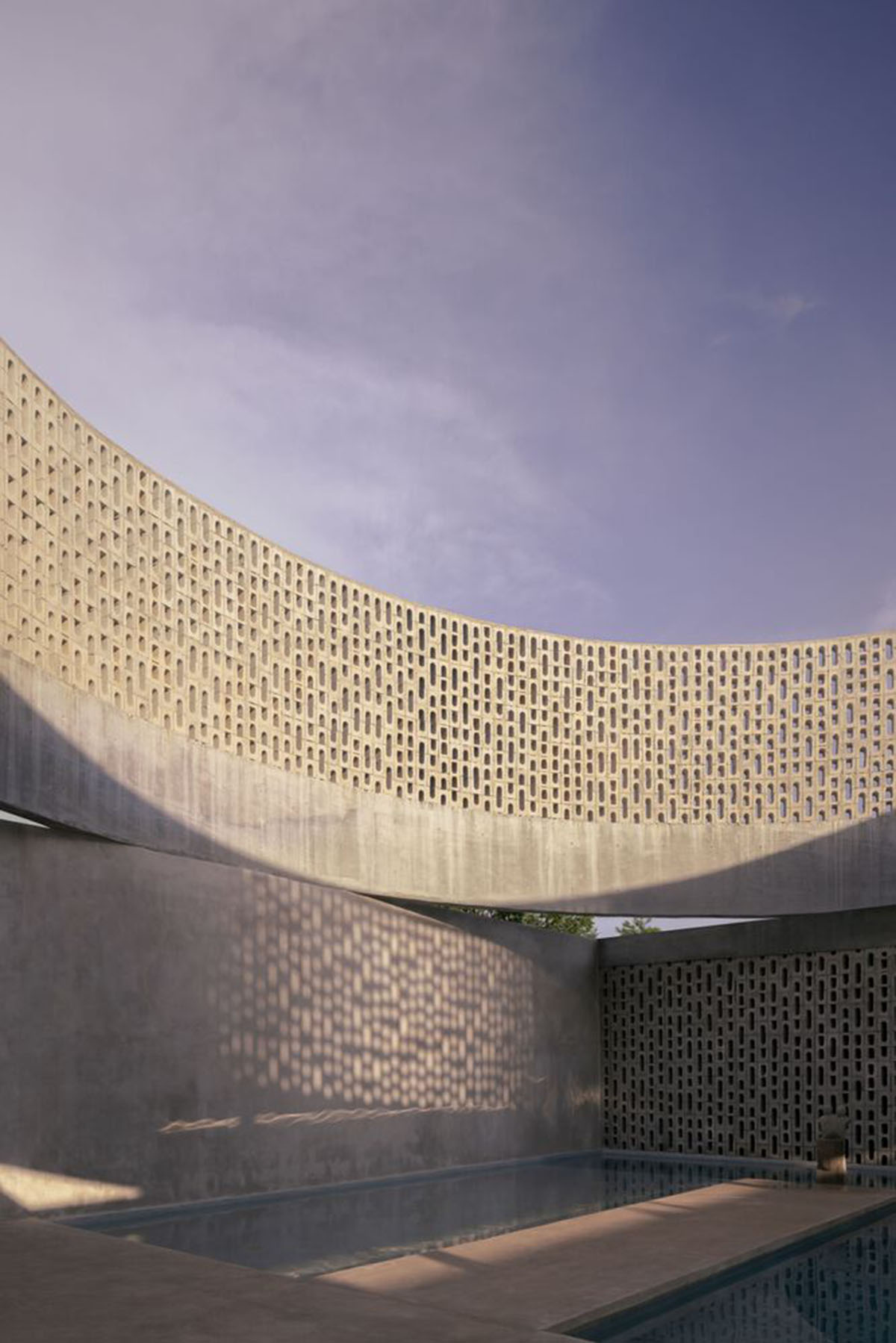 Perforated walls and cylindrical courtyard provide play of light in Wóolis House in Mexico