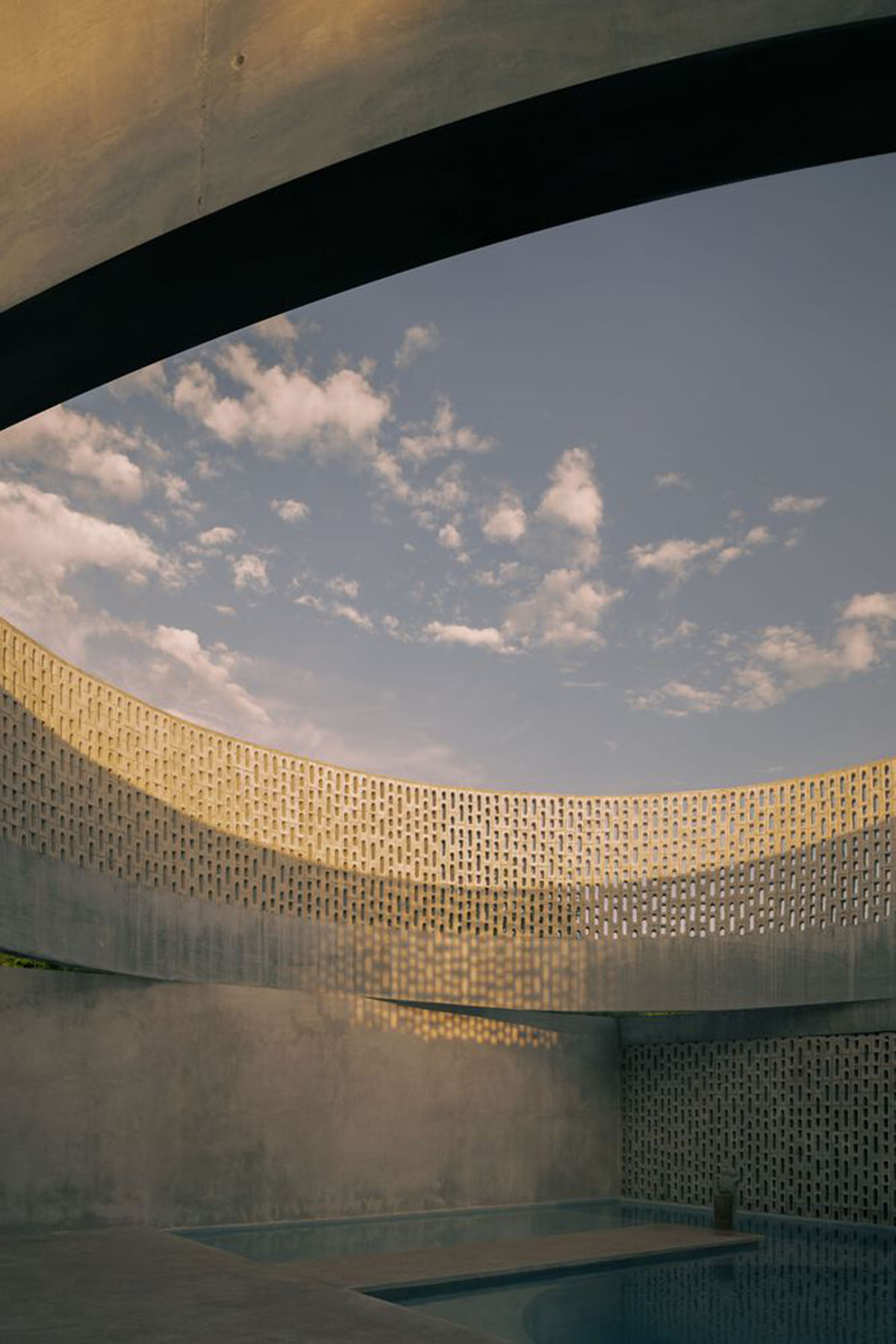 Perforated walls and cylindrical courtyard provide play of light in Wóolis House in Mexico