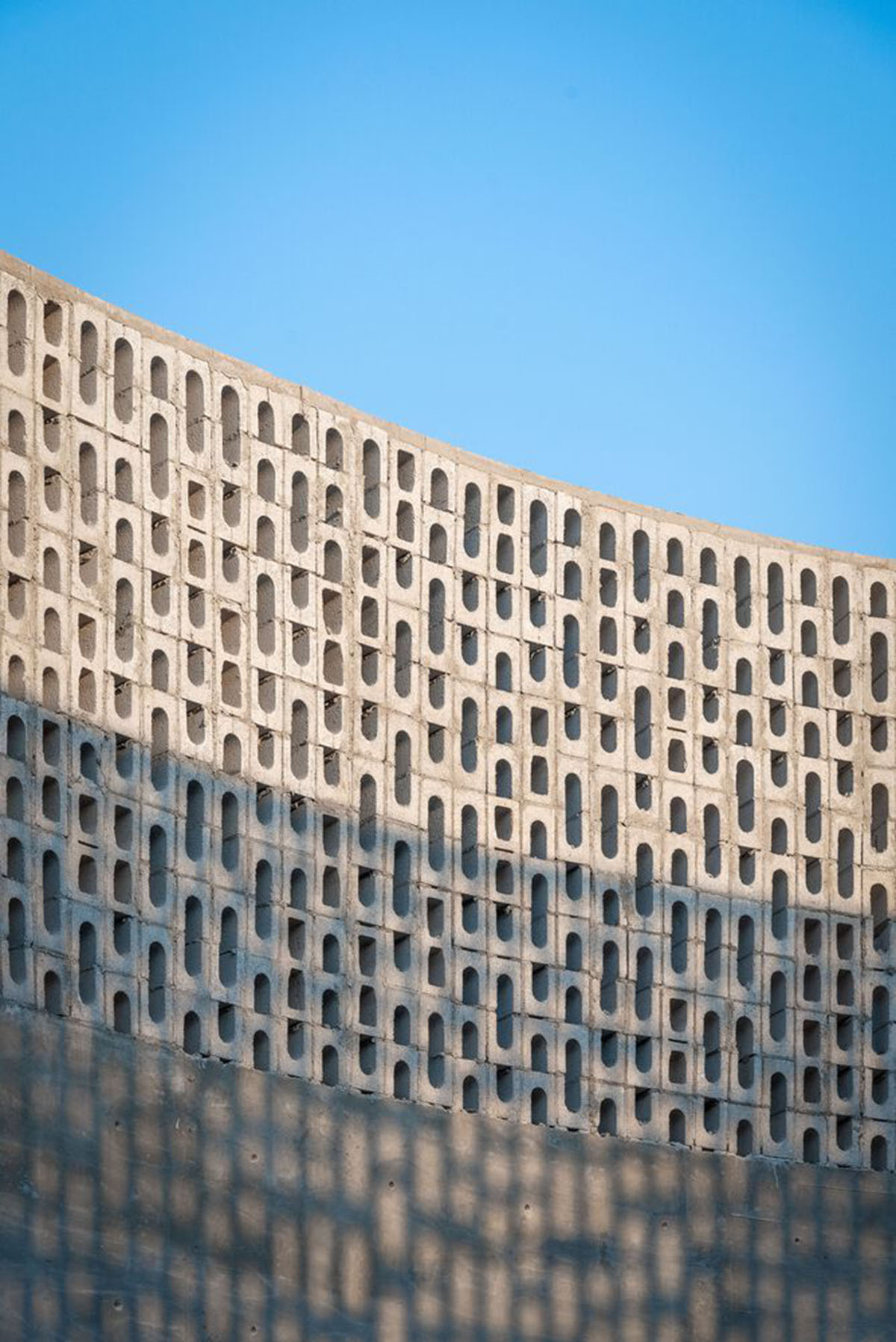 Perforated walls and cylindrical courtyard provide play of light in Wóolis House in Mexico