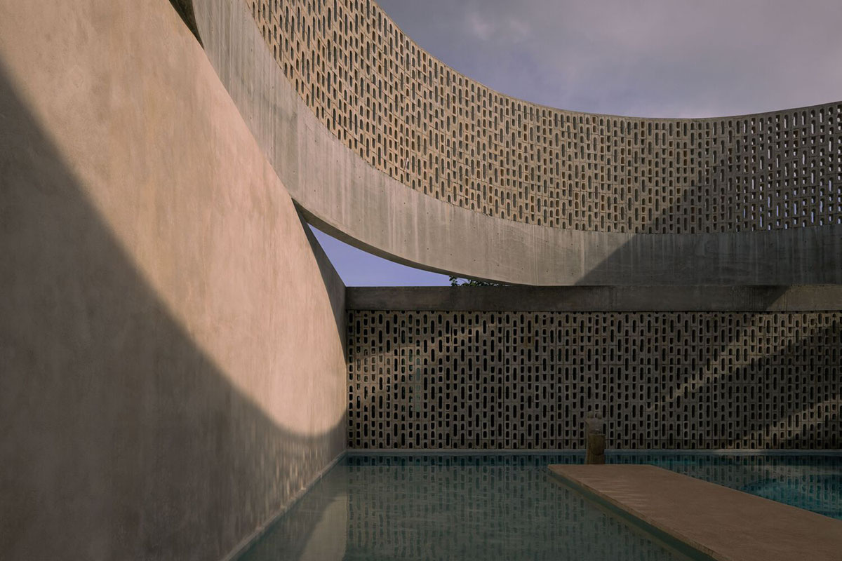 Perforated walls and cylindrical courtyard provide play of light in Wóolis House in Mexico