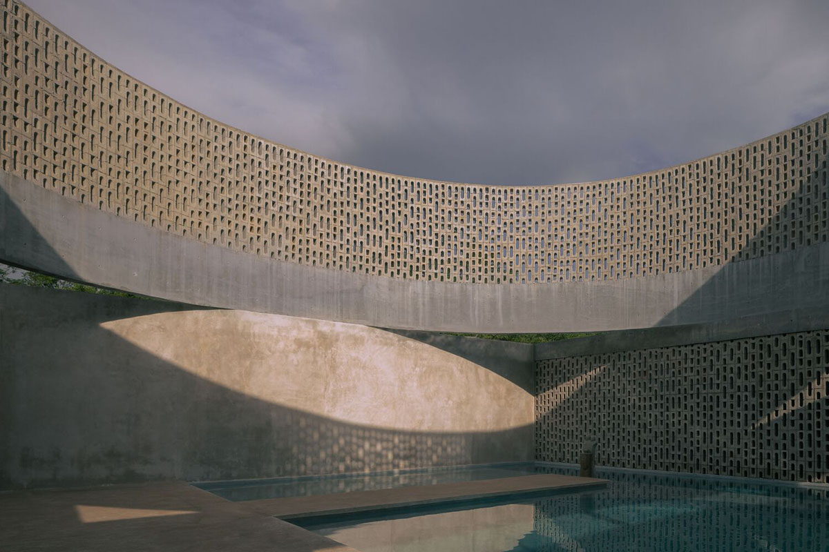 Perforated walls and cylindrical courtyard provide play of light in Wóolis House in Mexico