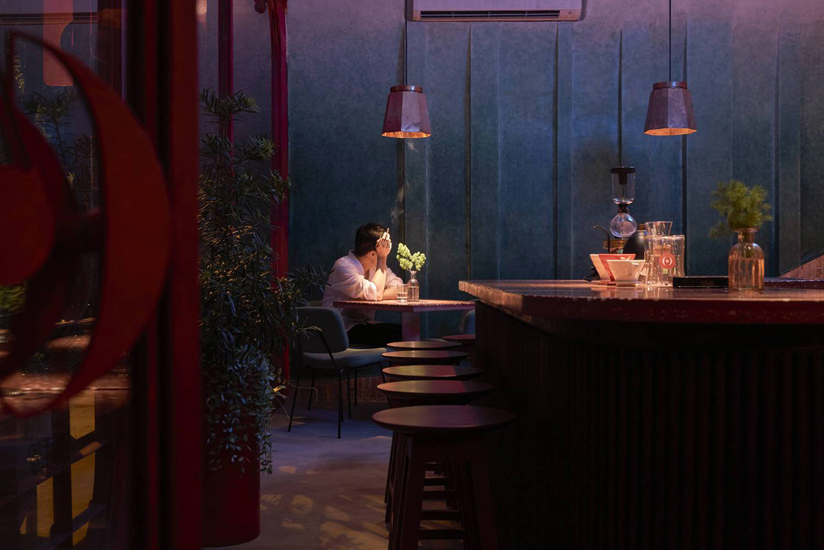 Red5studio built cafe evoking a retro spirit with hues of red colors and lights in Vietnam