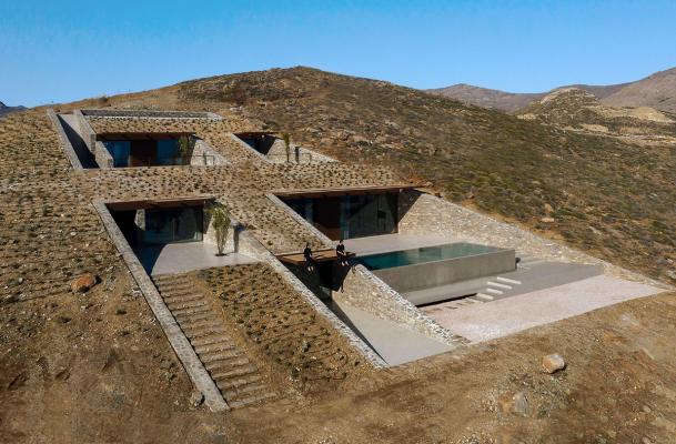 MOLD Architects used advantages of sloping land to design Ncaved house in Greece